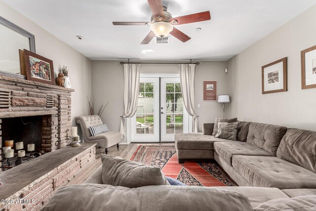 3420 N Kachina Ln, Scottsdale, AZ 85251 - living area featuring wood finished floors, a ceiling fan, and a stone fireplace