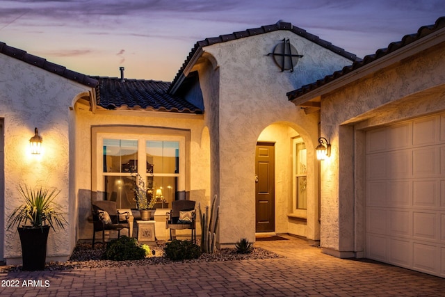 exterior entry at dusk with a garage