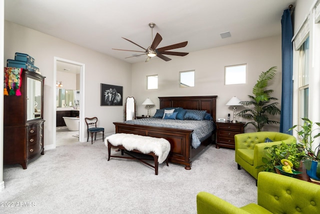 bedroom featuring ceiling fan, light colored carpet, connected bathroom, and multiple windows