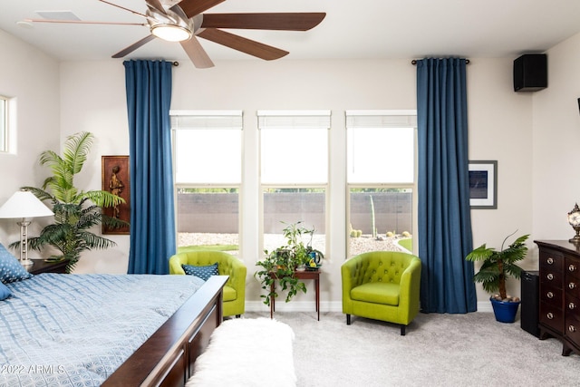 carpeted bedroom featuring multiple windows and ceiling fan