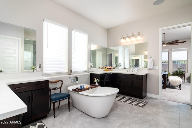 bathroom with tile patterned flooring, vanity, ceiling fan, and a tub to relax in