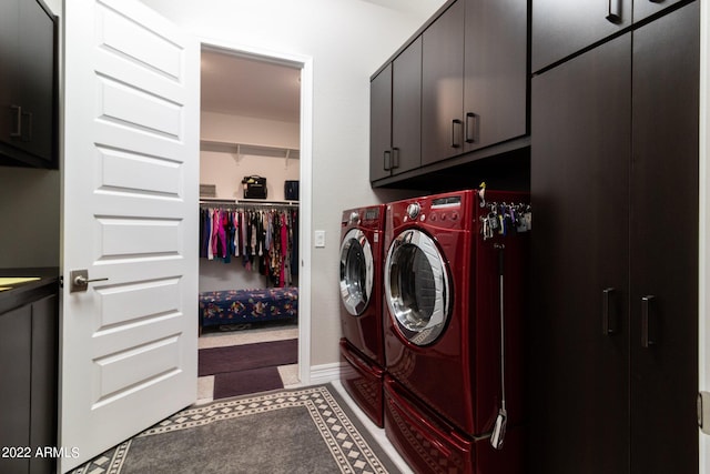 clothes washing area featuring independent washer and dryer and cabinets