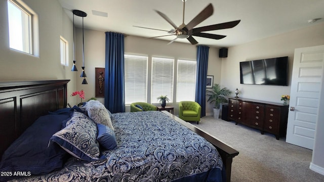 carpeted bedroom with multiple windows and ceiling fan