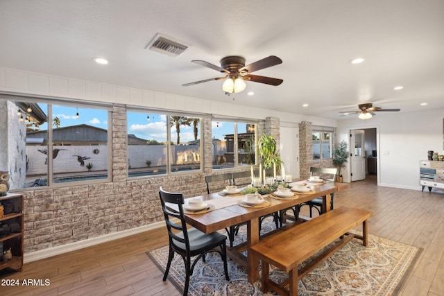 dining space with ceiling fan and wood-type flooring