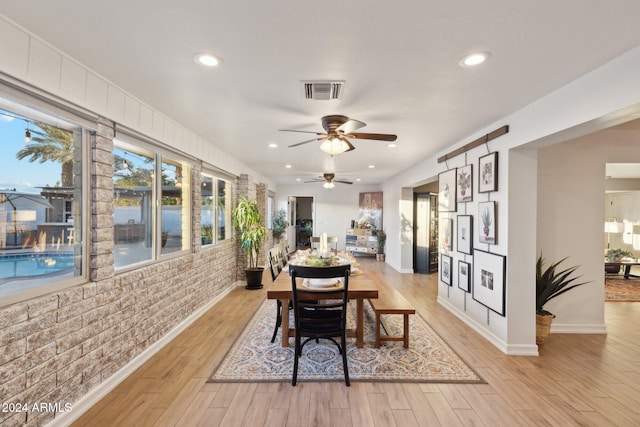 dining room with brick wall and light wood-type flooring