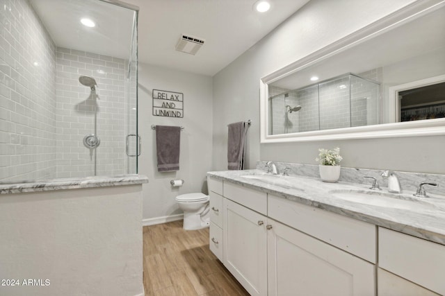 bathroom with toilet, wood-type flooring, vanity, and an enclosed shower