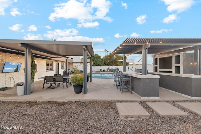 view of patio with exterior bar, a fenced in pool, and a pergola