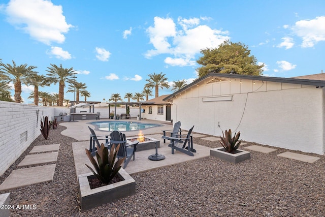 exterior space featuring a hot tub, a fire pit, and a patio