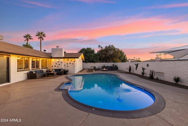 pool at dusk featuring an outdoor living space and a patio