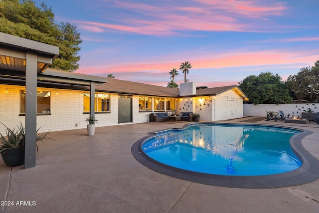 pool at dusk featuring a patio