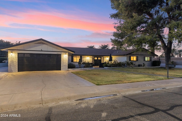 single story home with a lawn and a garage