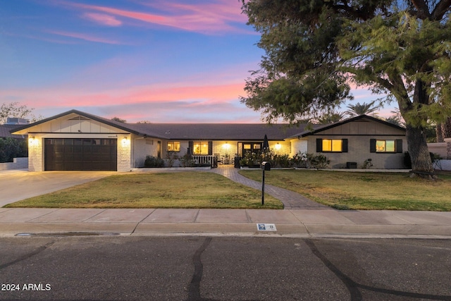 single story home featuring a lawn and a garage