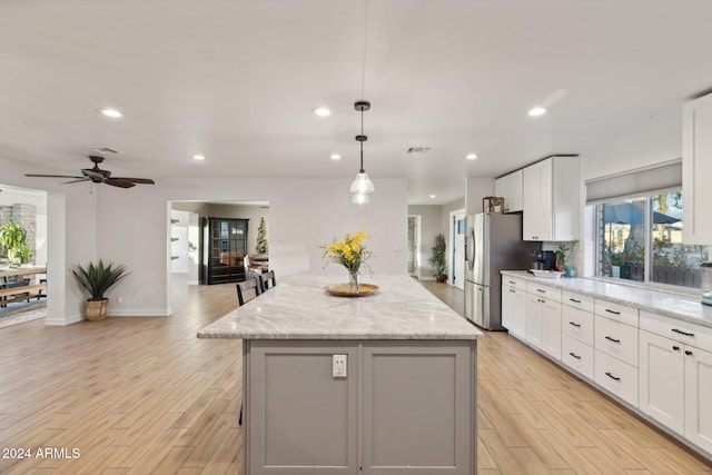 kitchen with decorative light fixtures, white cabinets, and a kitchen island