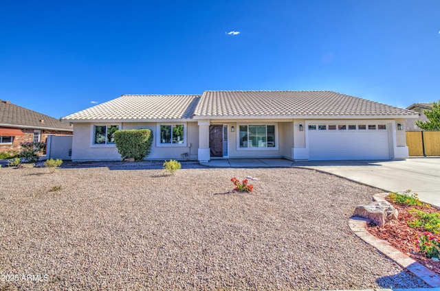 single story home featuring a tiled roof, concrete driveway, a garage, stucco siding, and fence