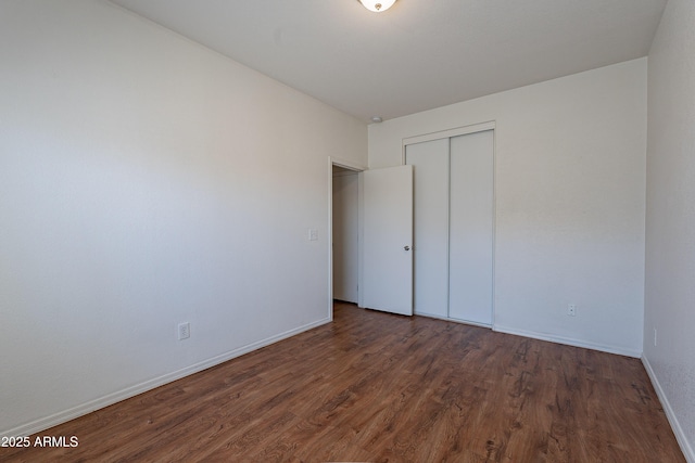 14244 N 132nd Ln, Surprise, AZ 85379 - unfurnished bedroom with a closet, baseboards, and wood finished floors