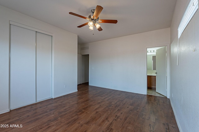 14244 N 132nd Ln, Surprise, AZ 85379 - unfurnished bedroom featuring a closet, baseboards, ensuite bath, visible vents, and dark wood-type flooring
