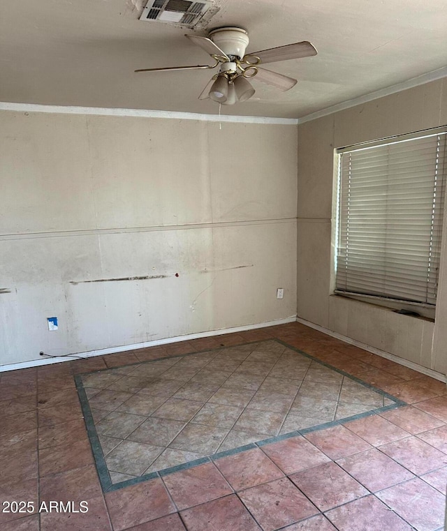 spare room with ceiling fan, visible vents, crown molding, and tile patterned floors