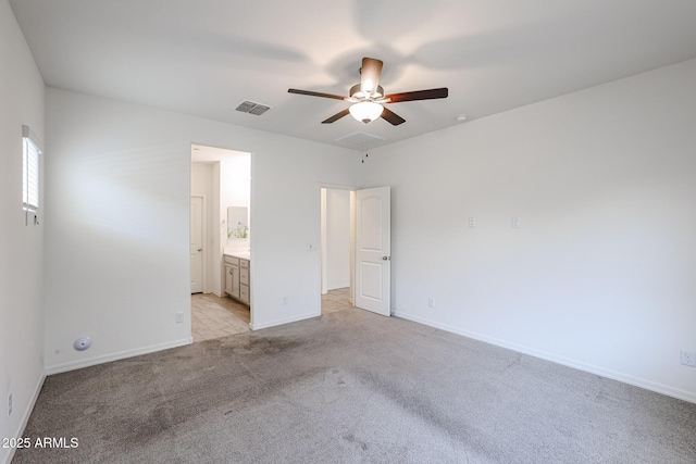 unfurnished bedroom with connected bathroom, light colored carpet, and ceiling fan