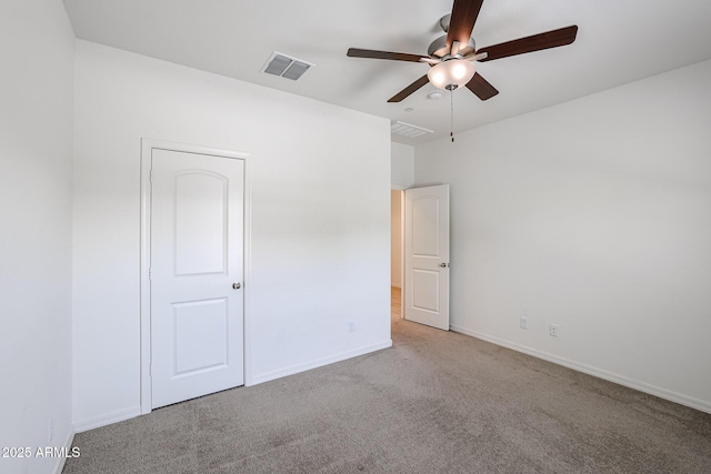 empty room featuring ceiling fan and light carpet