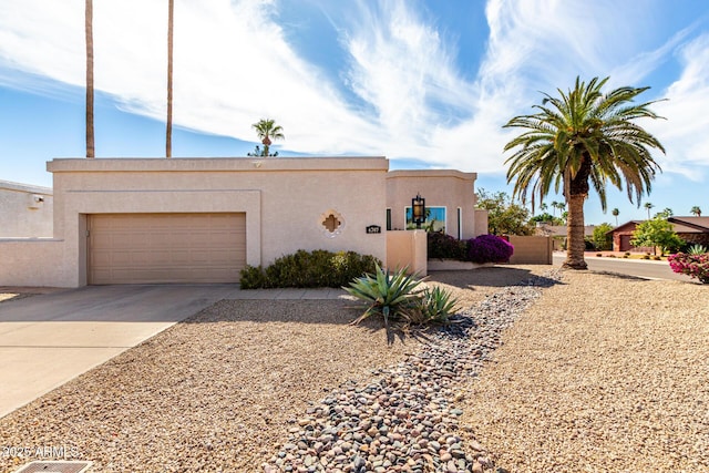 view of front of property with concrete driveway, an attached garage, and stucco siding