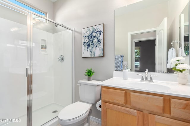 bathroom featuring toilet, a shower stall, and vanity