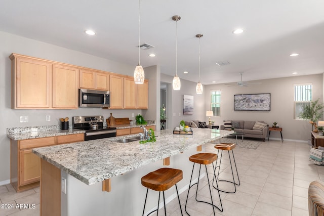 kitchen featuring light brown cabinetry, sink, ceiling fan, and stainless steel appliances