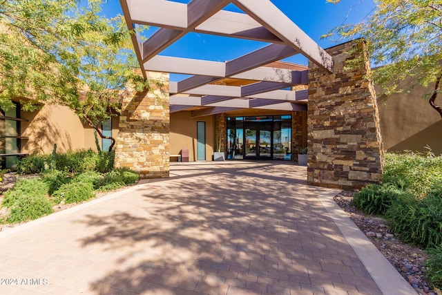 doorway to property featuring stone siding and stucco siding