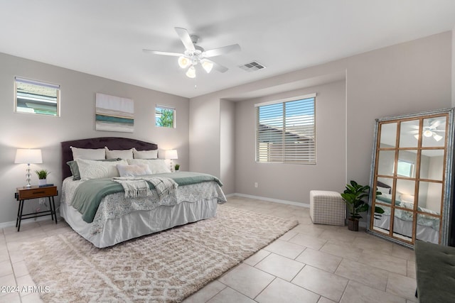 tiled bedroom featuring a ceiling fan, visible vents, and baseboards