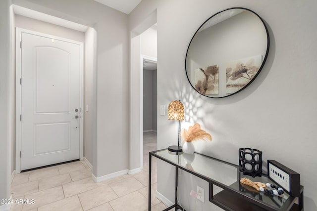 entryway with baseboards and light tile patterned floors