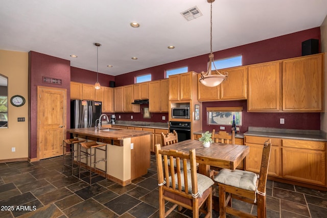 11540 S Morningside Dr, Goodyear, AZ 85338 - kitchen featuring visible vents, a sink, a kitchen island with sink, under cabinet range hood, and black appliances