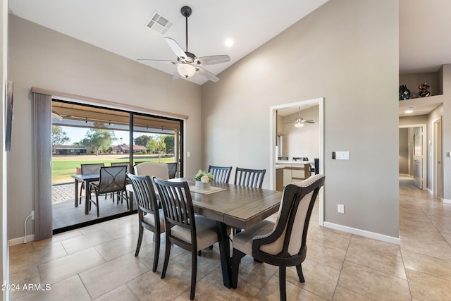 tiled dining area featuring ceiling fan and high vaulted ceiling