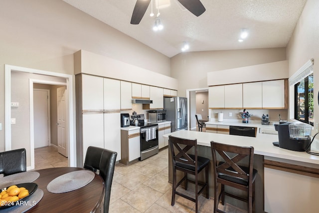 kitchen with white cabinets, appliances with stainless steel finishes, a textured ceiling, and kitchen peninsula