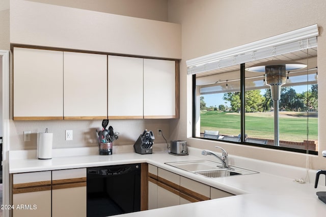 kitchen with dishwasher, white cabinets, and sink