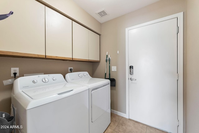 laundry area featuring independent washer and dryer, cabinets, and light tile patterned floors