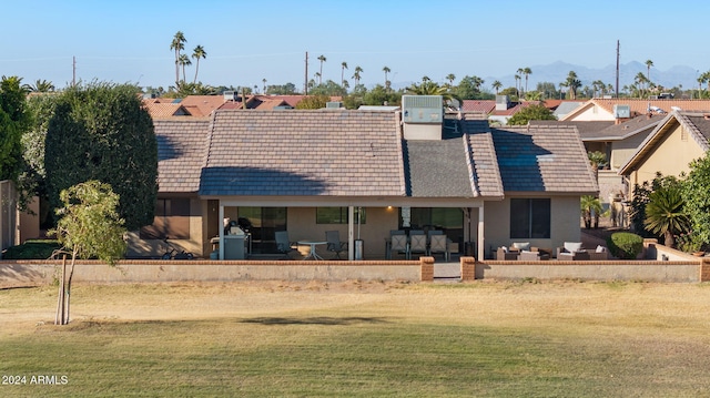 rear view of house featuring a patio area and a yard