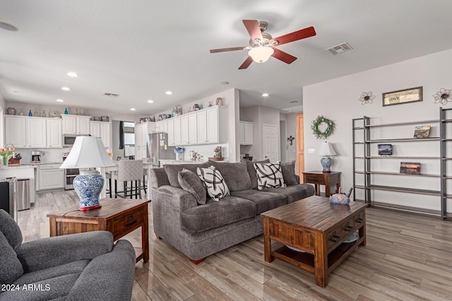 living room with light wood-type flooring and ceiling fan