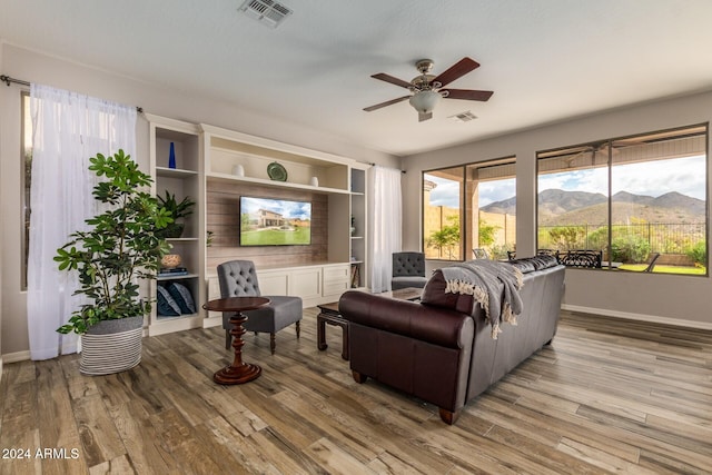 living room featuring light hardwood / wood-style flooring and ceiling fan