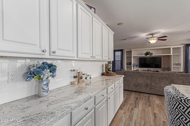 kitchen with white cabinetry, light hardwood / wood-style flooring, ceiling fan, and a textured ceiling