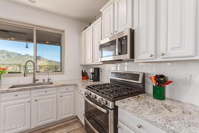 kitchen featuring a mountain view, appliances with stainless steel finishes, white cabinets, and sink