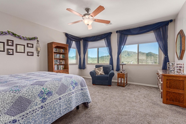 bedroom featuring ceiling fan, carpet floors, and a mountain view