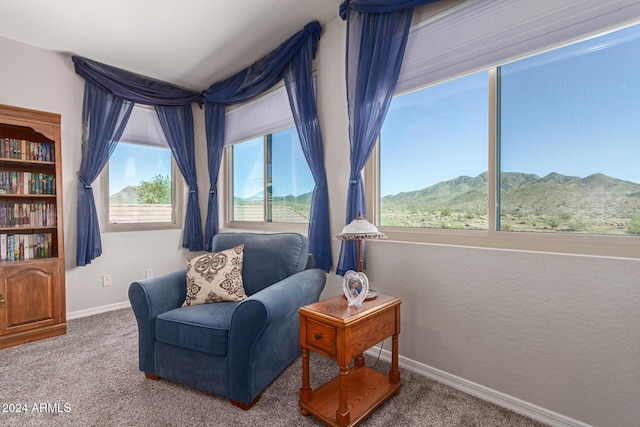 living area with carpet flooring, a mountain view, and plenty of natural light