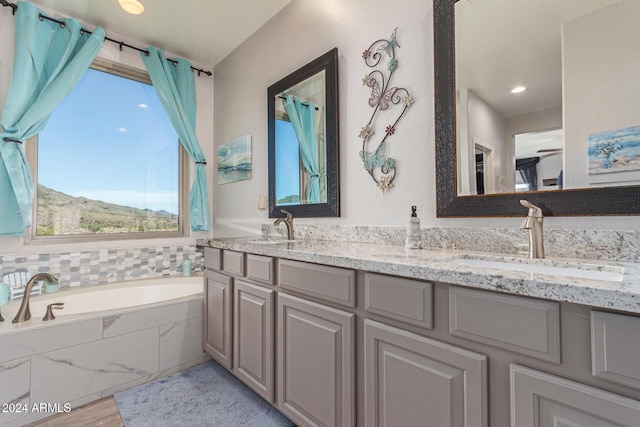 bathroom with hardwood / wood-style flooring, vanity, a mountain view, and tiled bath