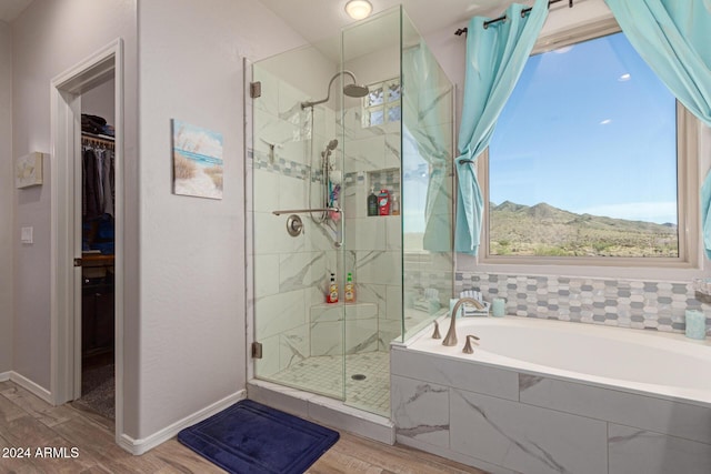 bathroom with a mountain view, wood-type flooring, and shower with separate bathtub