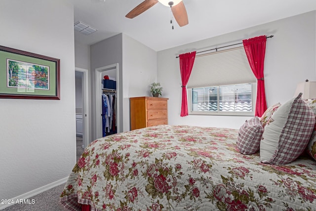 carpeted bedroom featuring ceiling fan, a spacious closet, and a closet