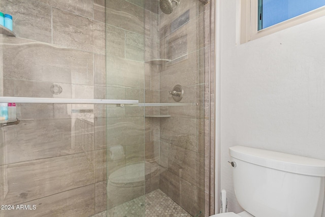 bathroom with toilet and a shower with shower door