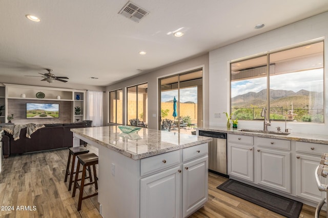 kitchen featuring a mountain view, a center island, dishwasher, white cabinets, and sink