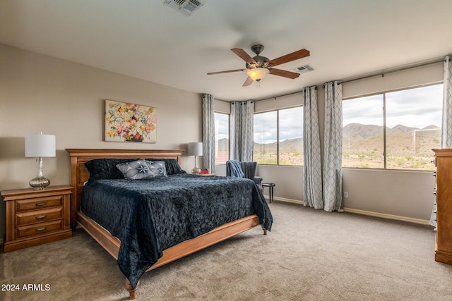 carpeted bedroom featuring a mountain view and ceiling fan