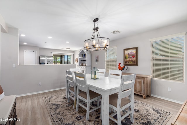 dining room featuring light hardwood / wood-style flooring and a chandelier