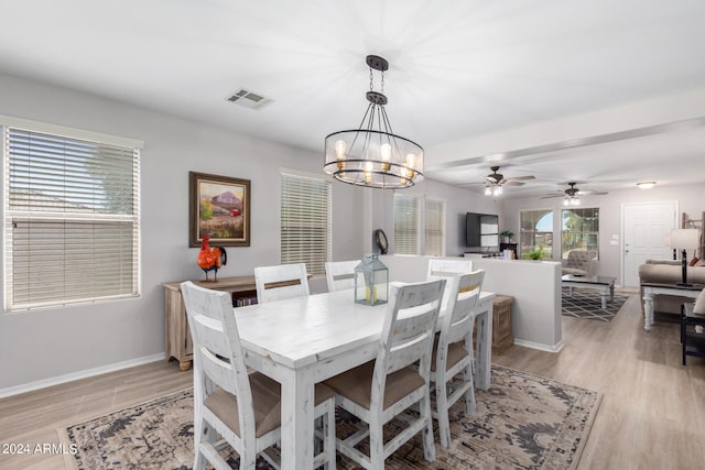 dining area featuring ceiling fan with notable chandelier and light hardwood / wood-style floors