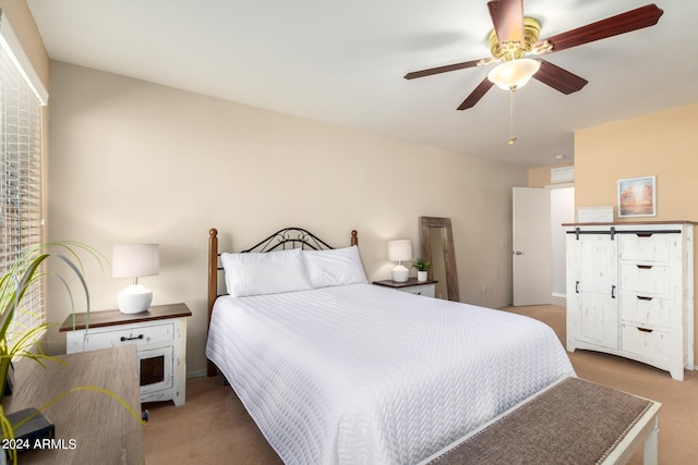 bedroom with carpet floors, a barn door, and ceiling fan